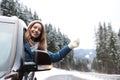 Young woman driving car and looking out of window. Winter vacation Royalty Free Stock Photo