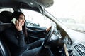 Young woman driving a car and talking on the smartphone Royalty Free Stock Photo