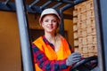 The young woman is driving a forklift in a warehouse Royalty Free Stock Photo