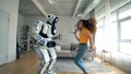 Young woman and droid dance together. Cyborg and human concept.