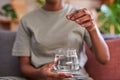 A young woman drops a fizzy effervescent tablet into a glass of water for flu Royalty Free Stock Photo