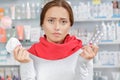 Young woman in drugstore with handkerchief and pills