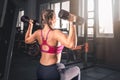 Young woman with dumbbells in the gym. Portrait of young attractive woman in sport clothes holding weight dumbbell doing fitness Royalty Free Stock Photo