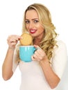 Young Woman Dunking a Biscuit in a Mug of Tea Royalty Free Stock Photo