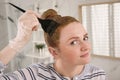 Young woman dyeing hair with henna in bathroom