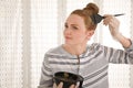 Young woman dyeing her hair with henna indoors, space for text