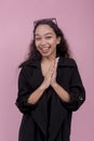 A young woman eagerly anticipates a plan coming to fruition, rubbing her hands in excitement. Isolated on a light pink background