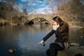 A young woman early in the morning is sitting in the central park of New York and is looking on the lake. One person Royalty Free Stock Photo