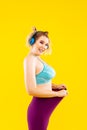 Young woman with earphones feeling proud after losing kilos Royalty Free Stock Photo