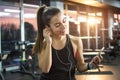 Young woman with earphones listening to music after hard workout in gym. Royalty Free Stock Photo