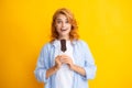Young woman eat ice creams with chocolate glaze on yellow background. Funny redhead woman with ice cream. Amazed Royalty Free Stock Photo
