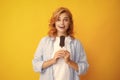 Young woman eat ice creams with chocolate glaze on yellow background. Funny redhead woman with ice cream. Amazed Royalty Free Stock Photo