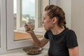 Young woman eat near the window a dry breakfast with yogurt Royalty Free Stock Photo