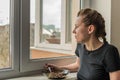 Young woman eat near the window a dry breakfast with yogurt Royalty Free Stock Photo