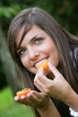 Young woman eating apricots