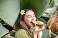 Woman eating avocado in banana leaves Royalty Free Stock Photo