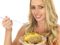 Young Woman Eating a Baked Potato with Cheese