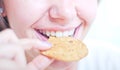 Young woman eating biscuit
