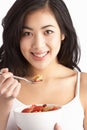 Young Woman Eating Bowl Of Cereal In Studio Royalty Free Stock Photo