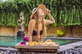 Young woman eating breakfast on a tray with fruit, buns, avocado sandwiches, smoothie bowl by the pool. Summer healthy Royalty Free Stock Photo