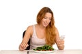 Young woman eating and chatting on mobile phone isolated white background Royalty Free Stock Photo