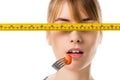 young woman eating cherry tomato with measuring tape in front her eyes Royalty Free Stock Photo