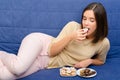 Young woman eating chocolate cookies.