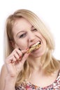 Young woman eating cookie with grimace Royalty Free Stock Photo