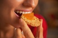 Young woman eating cookie with orange jam Royalty Free Stock Photo