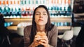 Young woman eating fatty hamburger.Craving fast food.Enjoying guilty pleasure,eating junk food.Satisfied expression.Breaking diet Royalty Free Stock Photo