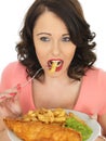 Young Woman Eating Fish and Chips with Mushy Peas Royalty Free Stock Photo