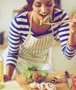 Young woman eating fresh salad in modern kitchen Royalty Free Stock Photo