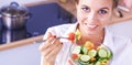 Young woman eating fresh salad in modern kitchen Royalty Free Stock Photo