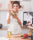 Young woman eating fresh salad in modern kitchen Royalty Free Stock Photo