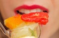 Young woman eating fruit salad