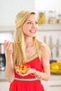 Young woman eating fruits salad in kitchen Royalty Free Stock Photo