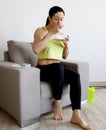 Young woman eating a healthy fruit salad after workout.