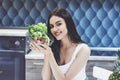 Young woman eating healthy salad with cherry tomatoes in the kitchen after a fitness session Royalty Free Stock Photo