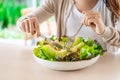 Young woman eating a healthy salad mixes with vegetable and fruit at the restaurant, Healthy lifestyle and diet concept Royalty Free Stock Photo