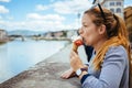 Young woman eating ice cream by the river in Florence Royalty Free Stock Photo