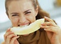 Young woman eating melon in kitchen Royalty Free Stock Photo