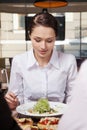 Young woman eating mixed vegetable salad in cafe. Woman eating healthy salad lunch in cafe with friends Royalty Free Stock Photo