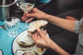 Young woman eating oyster shellfish and drinking white wine in a seafood restaurant. yellow toning, selective focus Royalty Free Stock Photo