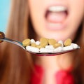 Young woman eating pills on a spoon Royalty Free Stock Photo