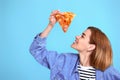 young woman eating pizza slice and looking delighted Royalty Free Stock Photo