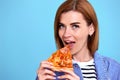 young woman eating pizza slice and looking delighted Royalty Free Stock Photo