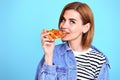 young woman eating pizza slice and looking delighted Royalty Free Stock Photo