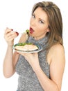 Young Woman Eating Poached Salmon and Salad