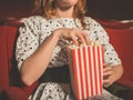 Young woman eating popcorn in movie theater Royalty Free Stock Photo