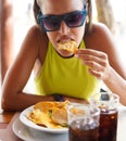 Young woman eating a portion of nachos with meat Royalty Free Stock Photo